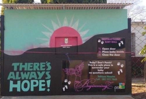 A colorful mural features a rising sun, the words THERES ALWAYS HOPE!, and instructions for a baby safe surrender box labeled Baby Wall with a phone number and angel illustration.