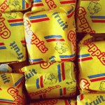A close-up of several yellow-wrapped Chappies fruit-flavored bubblegum pieces, with colorful red and blue stripes and the Chappies logo printed on the wrappers—classic treats that have sparked fun and unique business opportunities.