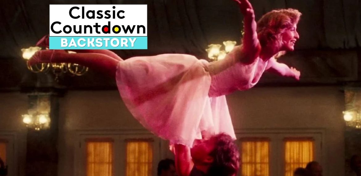 A woman in a pink dress is lifted in the air by her dance partner in a ballroom scene, capturing a moment where Love is in the Air. The words “Classic Countdown Backstory” appear in a box in the upper left corner of the image.