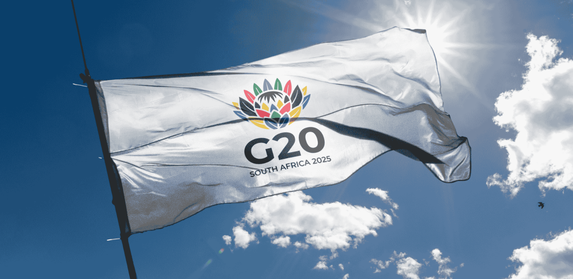 A white flag with a colorful flower emblem and the text G20 SOUTH AFRICA 2025 flutters against a sunny, blue sky, symbolizing new business opportunities on the global stage.