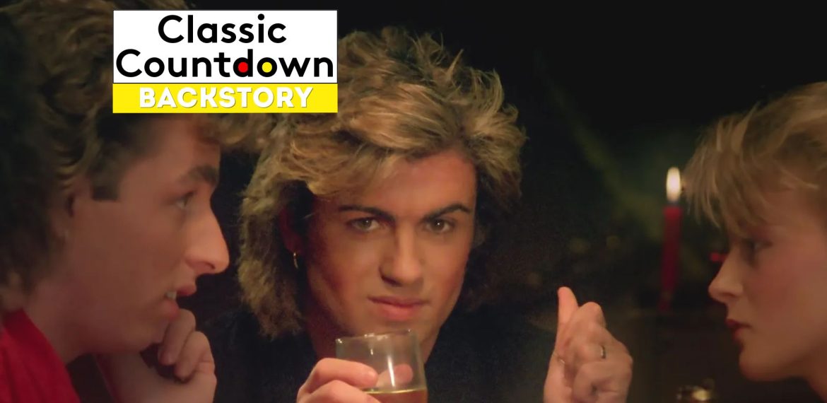 Three people sit together at a table. The center person, with styled blonde hair reminiscent of Prince, looks into the camera holding a glass. The image features a Classic Countdown Backstory logo in the top left corner.