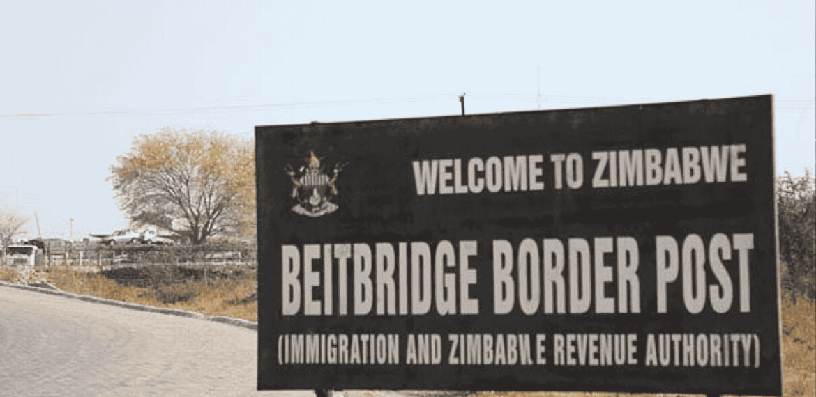A large sign reads “Welcome to Zimbabwe. Beitbridge Border Post (Immigration and Zimbabwe Revenue Authority)” next to a paved road, with trees and dry grass in the background, highlighting potential business opportunities at this busy crossing.